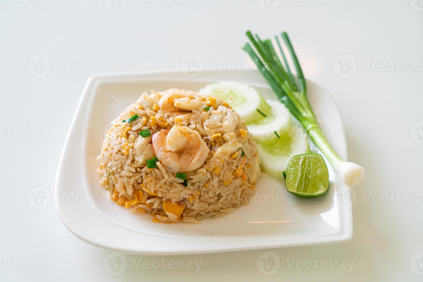 arroz frito com camarão e caranguejo no prato branco foto