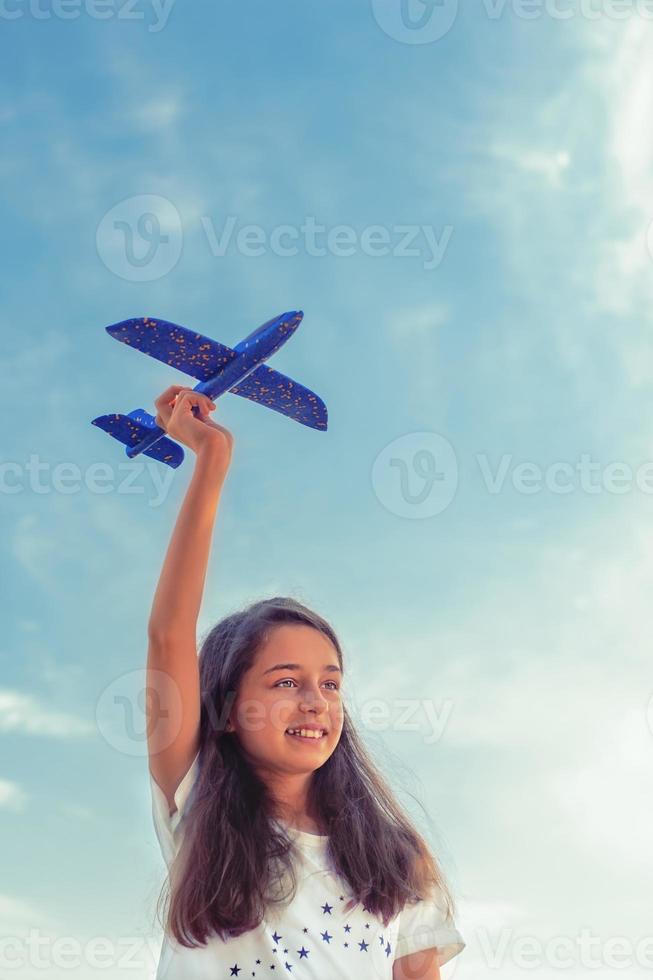 menina adolescente em um fundo do céu e um avião de brinquedo foto