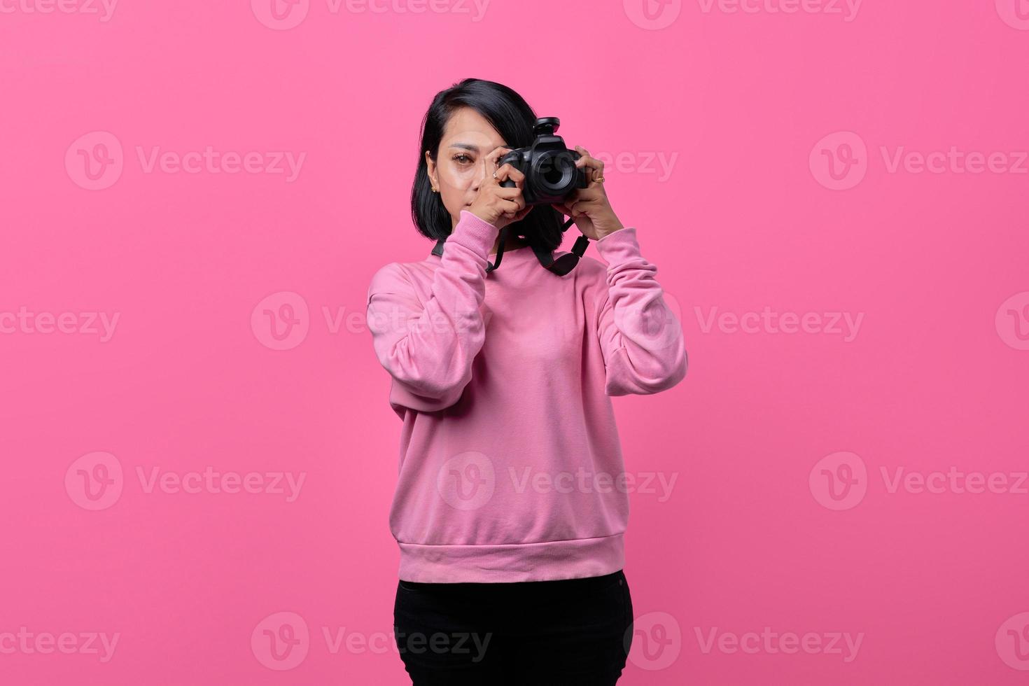 bela jovem segurando a câmera e pronta para tirar uma foto