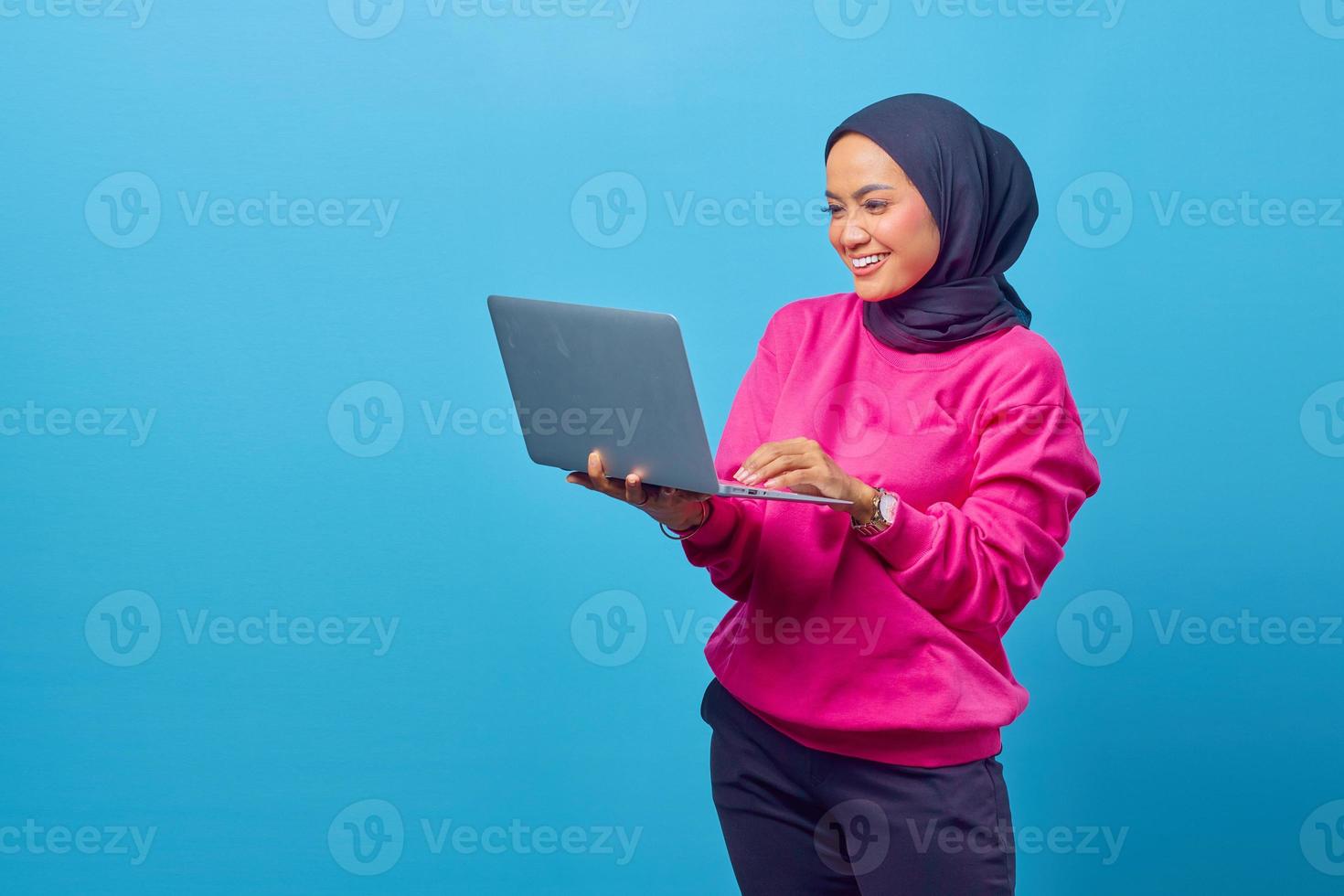 retrato de uma jovem asiática feliz usando um laptop foto