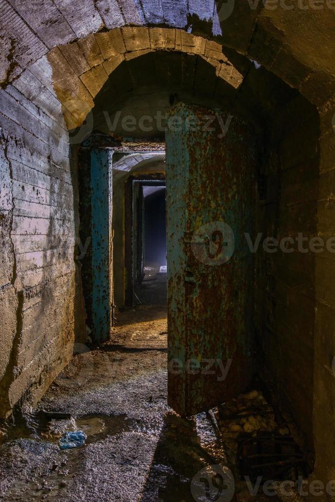 Porta blindada de metal enferrujado em antigo bunker soviético abandonado foto