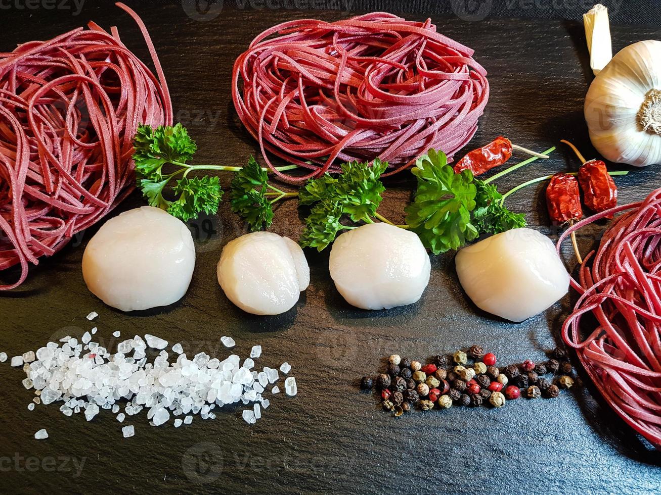 vieiras com ervas e especiarias de macarrão de linguine vermelho foto