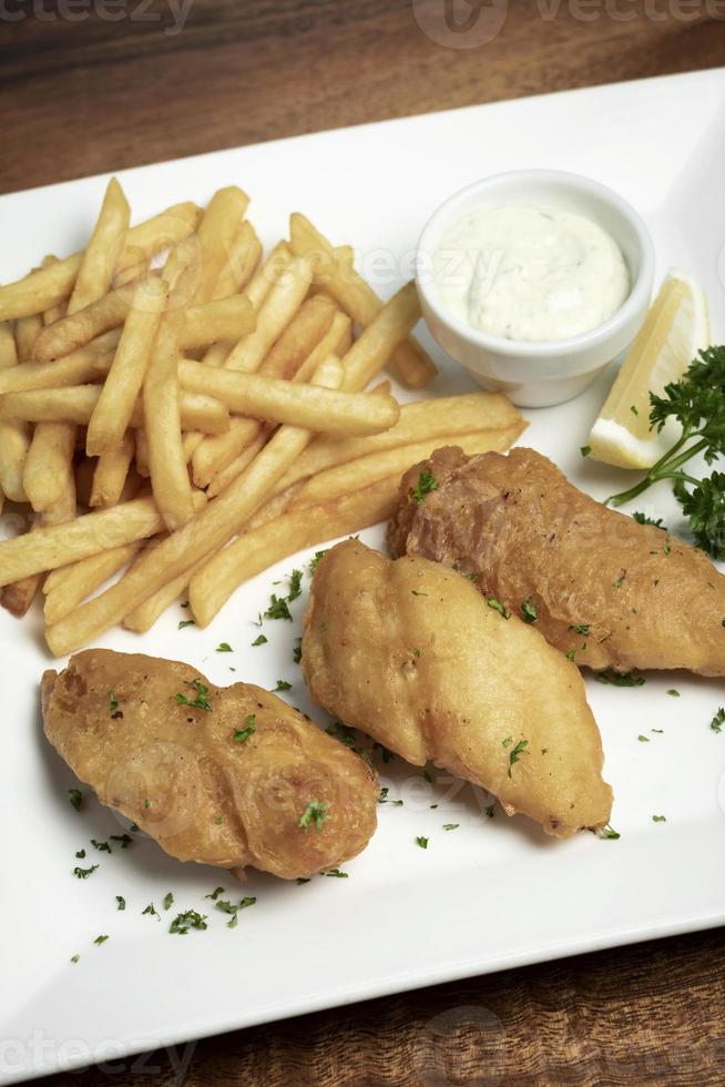 refeição tradicional britânica de peixe com batatas fritas em prato branco foto