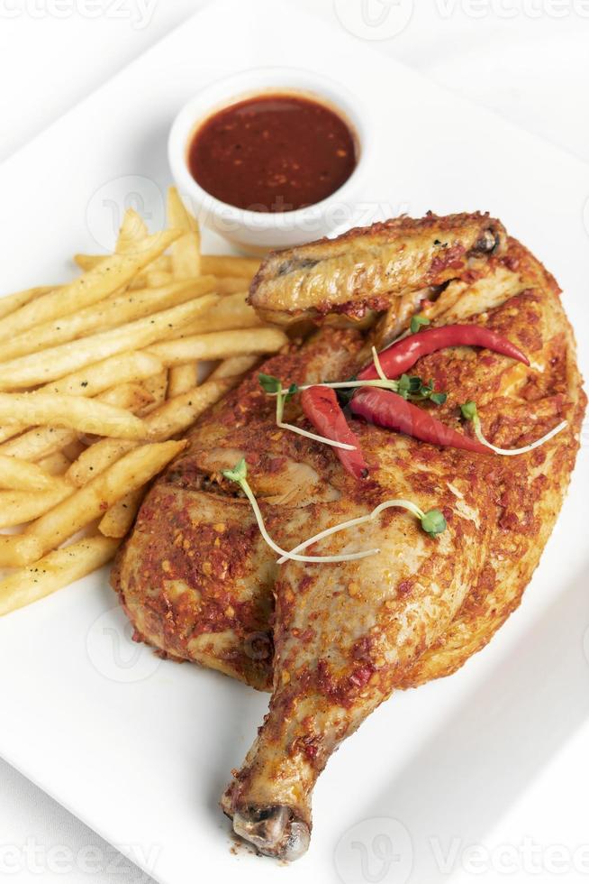 picante piri piri português meio frango assado com batata frita no prato em restaurante lisboa foto