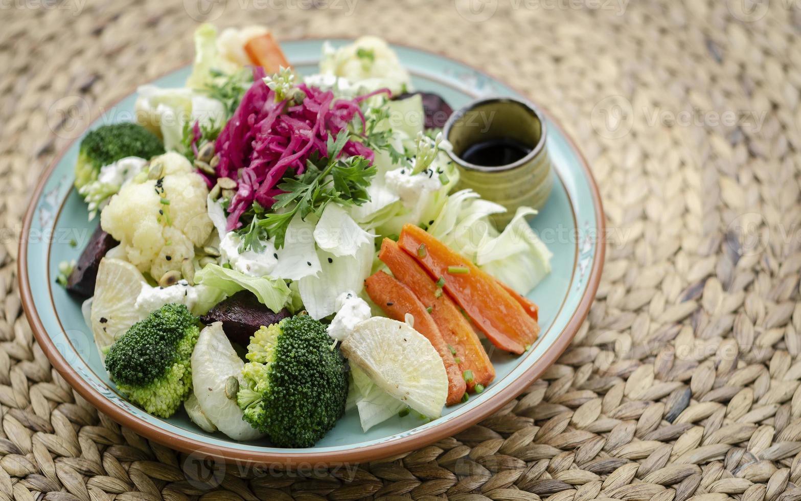 salada rústica com misturas saudáveis de vegetais frescos e cozidos no vapor em um prato colorido ao ar livre no jardim foto