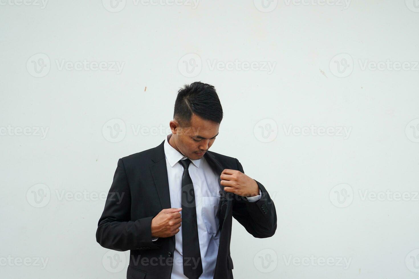 bonito jovem homem de negocios endireitar dele Preto terno em branco fundo foto