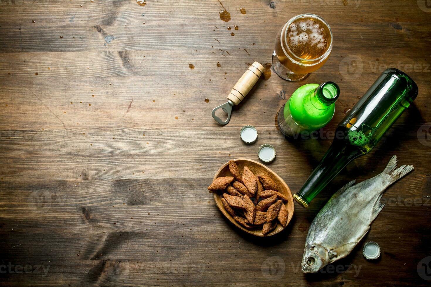 Cerveja com migalhas dentro tigela e seco peixe. foto