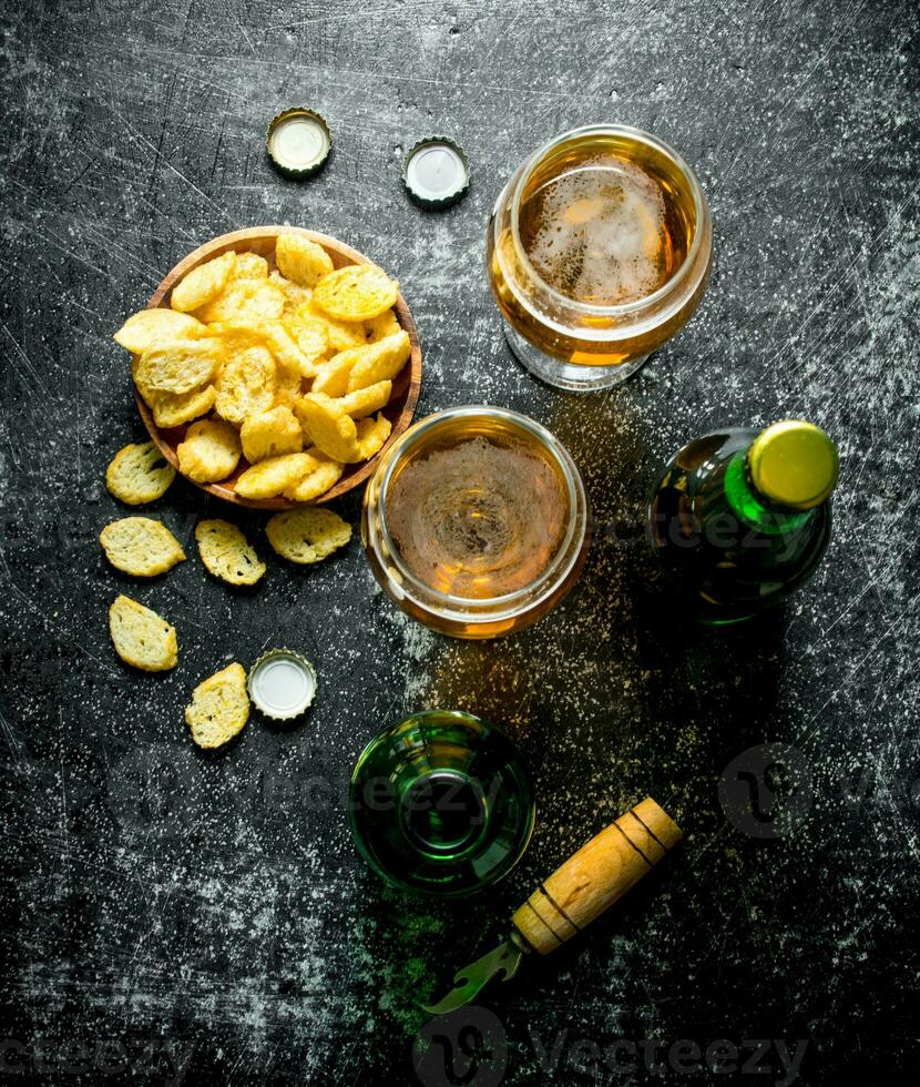 Cerveja dentro óculos e migalhas dentro tigela. foto