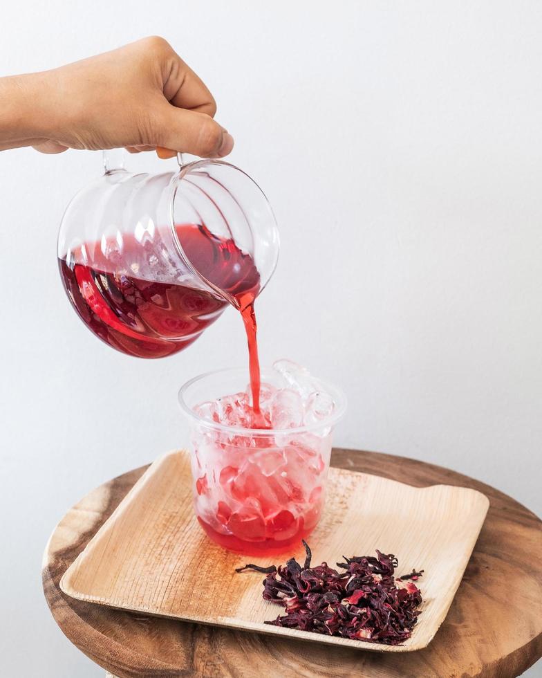 Suco de Roselle Gelado isolado em bandeja de madeira foto