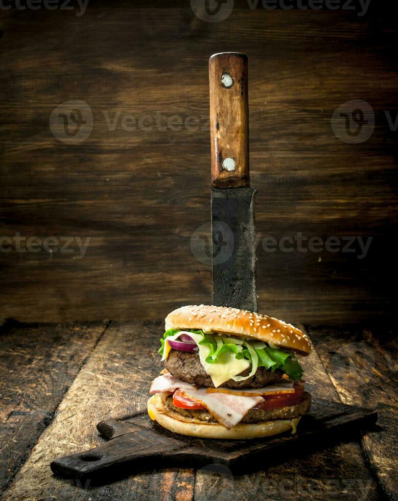 velozes Comida. uma fresco hamburguer fez a partir de carne e legumes com uma ampla faca. foto