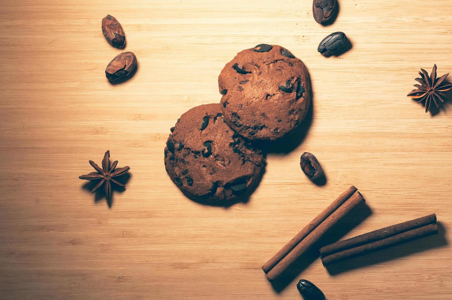 biscoitos de chocolate com especiarias e grãos de cacau na mesa foto