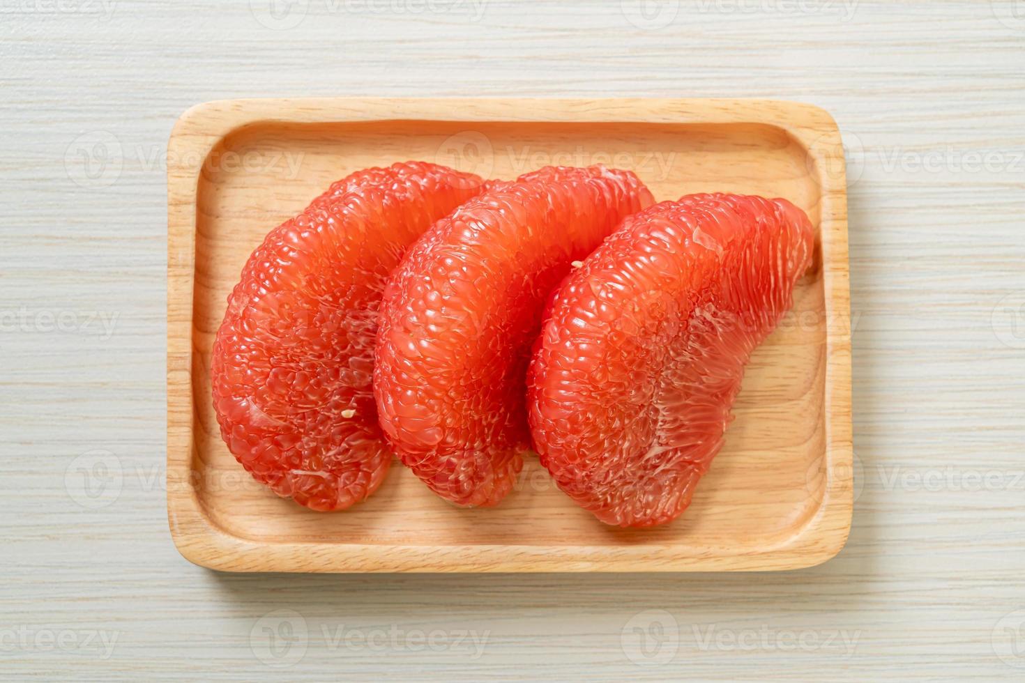 pomelo vermelho fresco ou toranja no prato foto