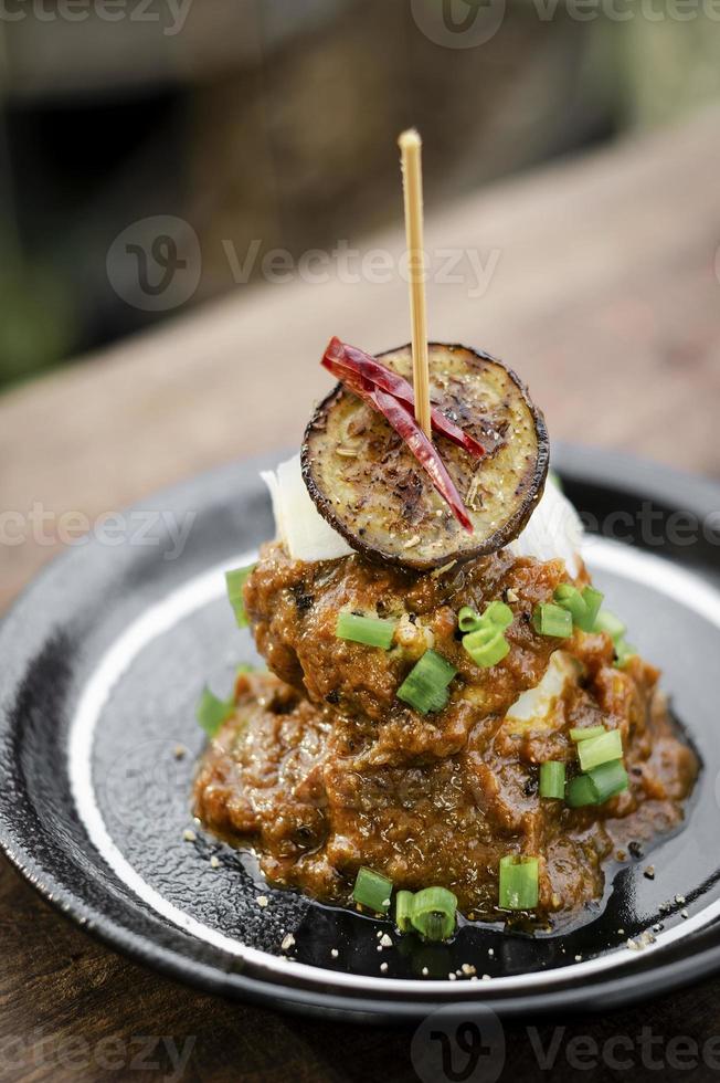 Bolos de quinoa vegan com berinjela assada siciliana e molho de pimenta vermelha picante tapas gourmet aperitivos petiscos foto