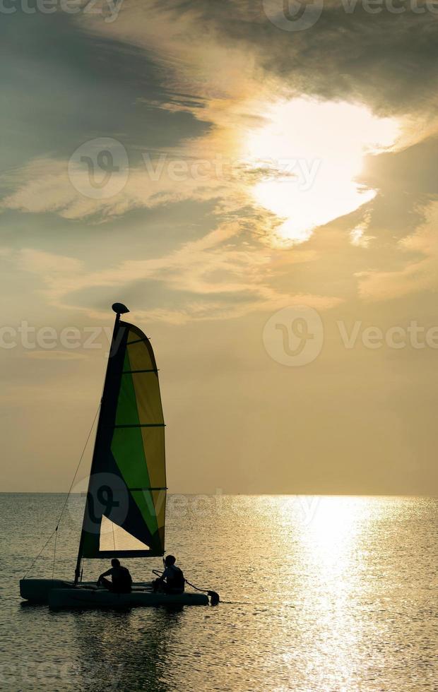 barco à vela no mar durante o pôr do sol na costa de phuket da tailândia foto