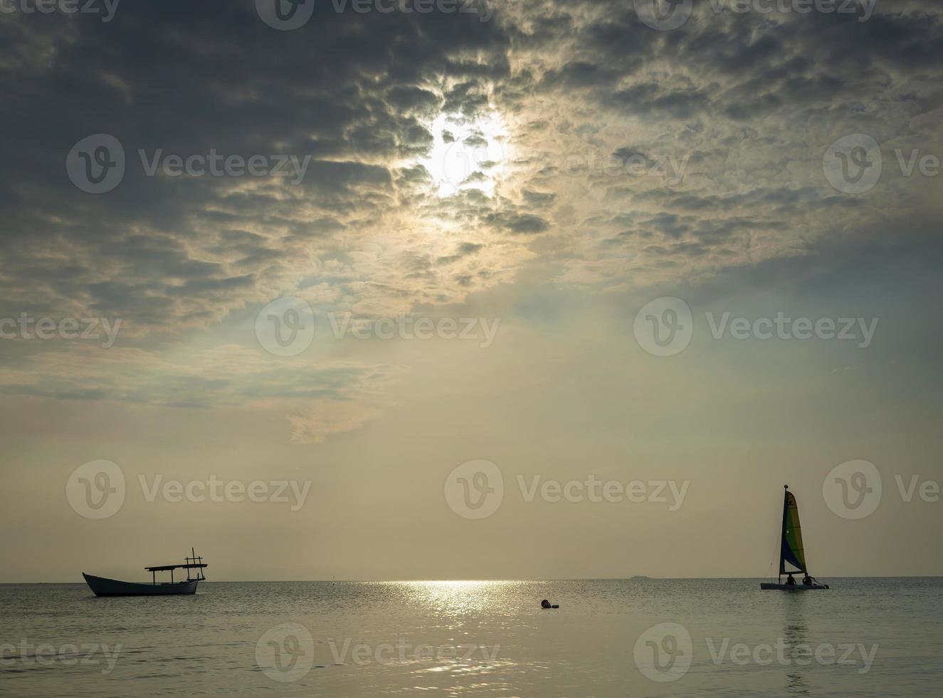 barco à vela no mar durante o pôr do sol na costa de phuket da tailândia foto