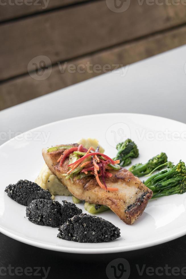 Filé de peixe vermelho pargo com legumes e arroz preto com sementes de gergelim preto prato asiático moderno de fusão em melbourne restaurante austrália foto