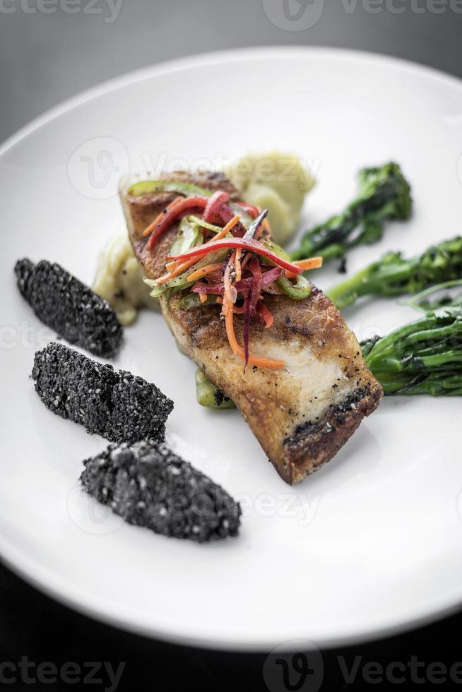 Filé de peixe vermelho pargo com legumes e arroz preto com sementes de gergelim preto prato asiático moderno de fusão em melbourne restaurante austrália foto