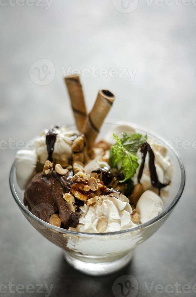 sobremesa sundae de sorvete de baunilha com chocolate orgânico e menta em uma tigela foto