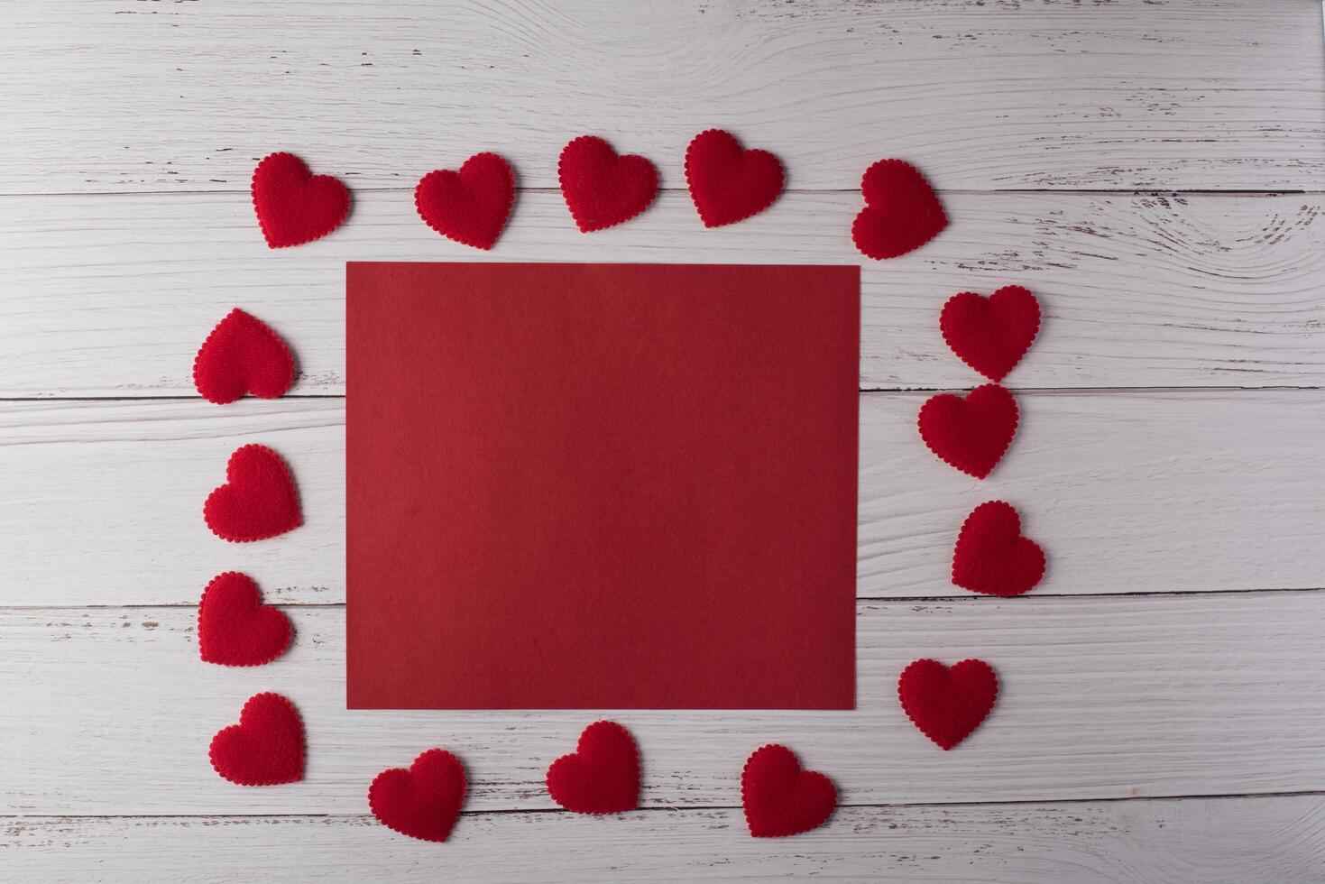 coração vermelho e cartão de nota vermelho em badkground de madeira branca. foto