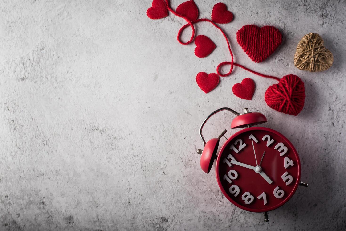 despertador vermelho com coração vermelho, conceito de dia dos namorados. foto