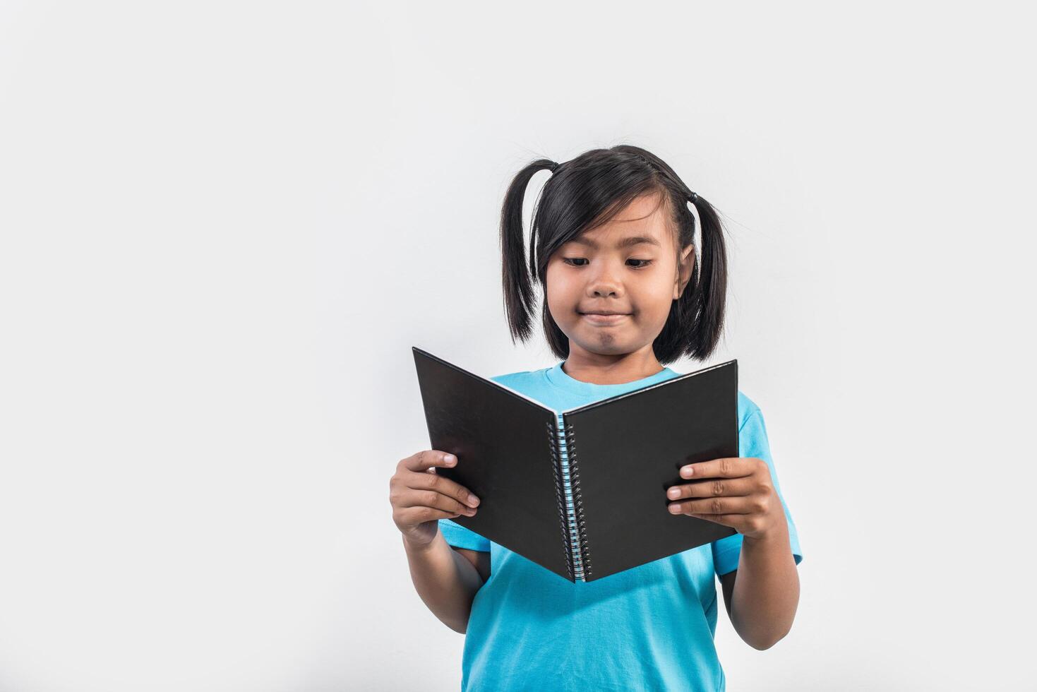 menina lendo livro em estúdio tiro. foto