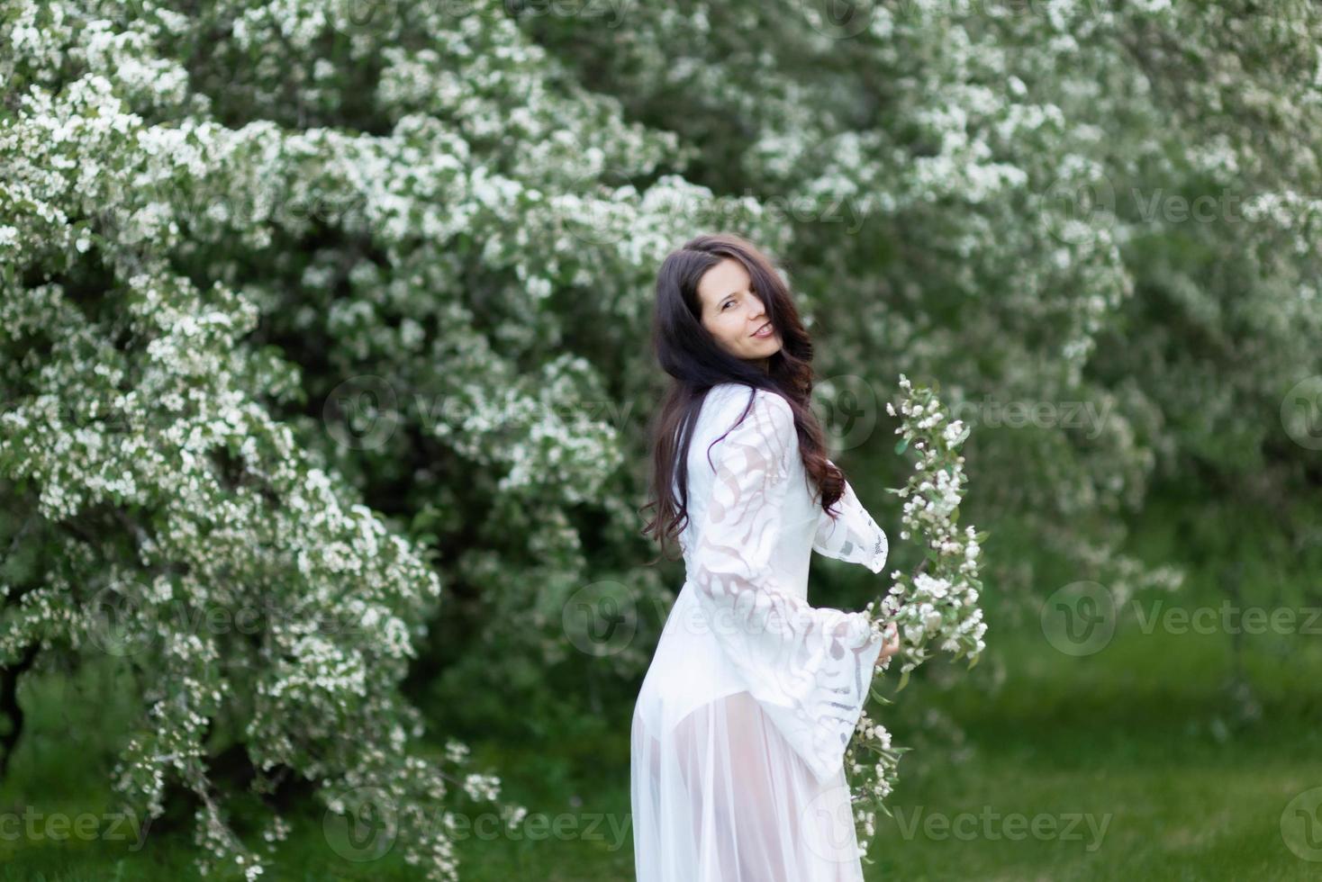 retrato de uma jovem no parque nos ramos floridos foto