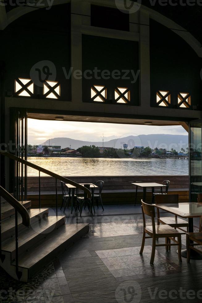 vista do restaurante do bar à beira do rio ao pôr do sol na cidade de Kampot no Camboja foto