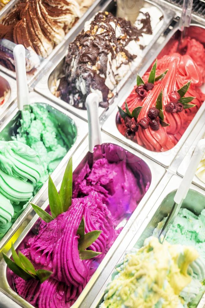 vários sabores de sorvete de gelato italiano em vitrine de loja moderna foto