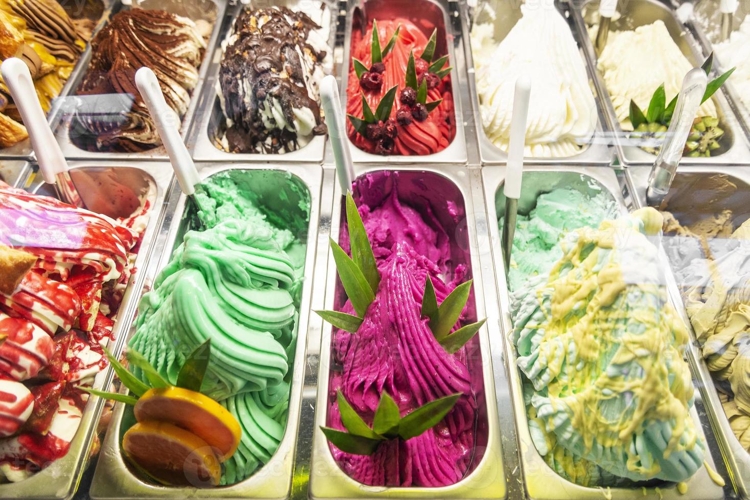 vários sabores de sorvete de gelato italiano em vitrine de loja moderna foto