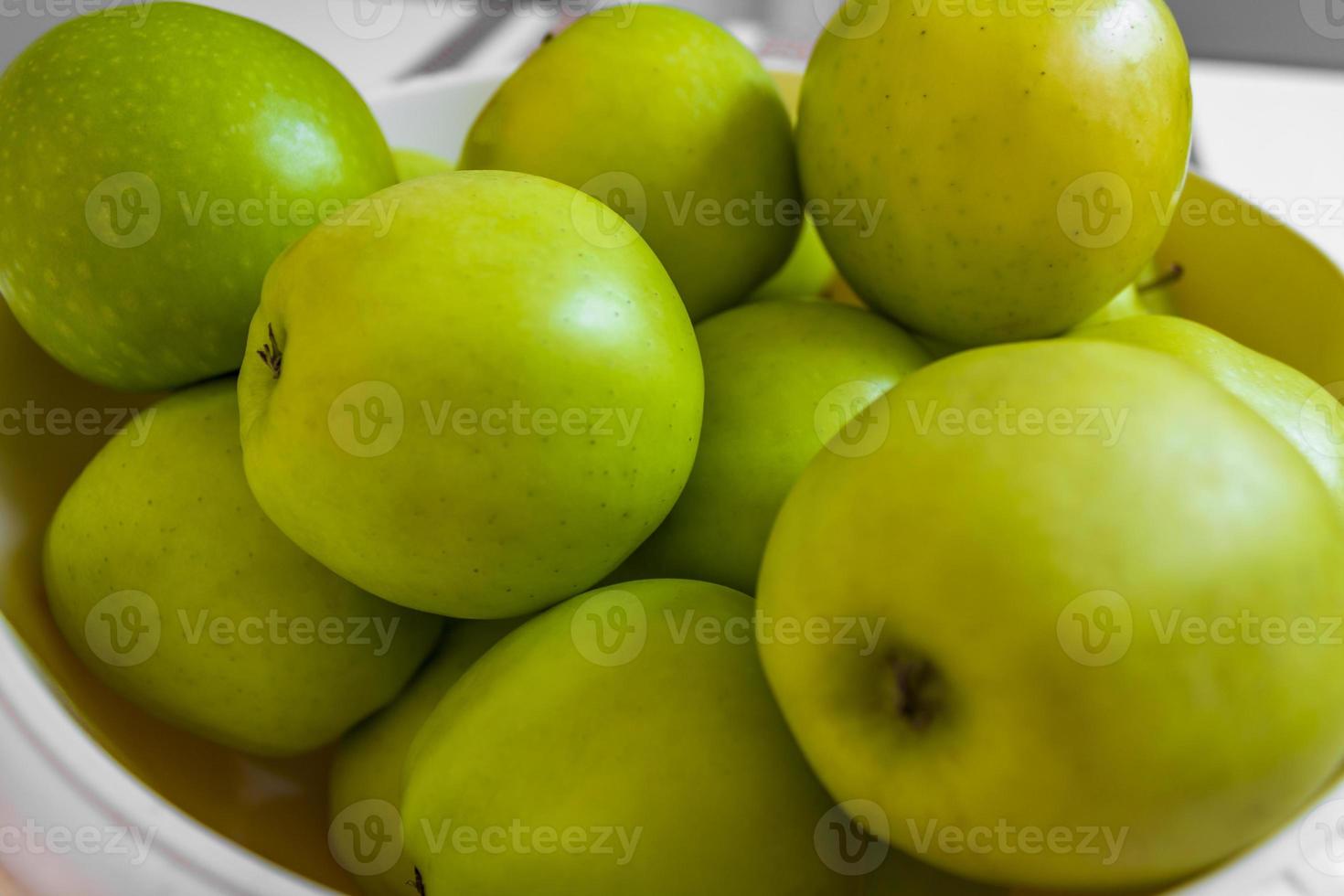 maçãs verdes azedas em um prato branco. foto