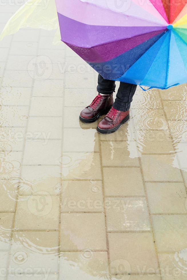 sapatos vermelhos de mulher em pé em uma poça na chuva foto