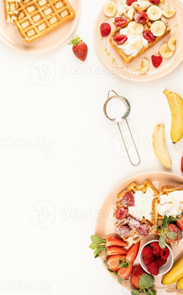 waffles com frutas e morangos, creme e mel em um prato foto