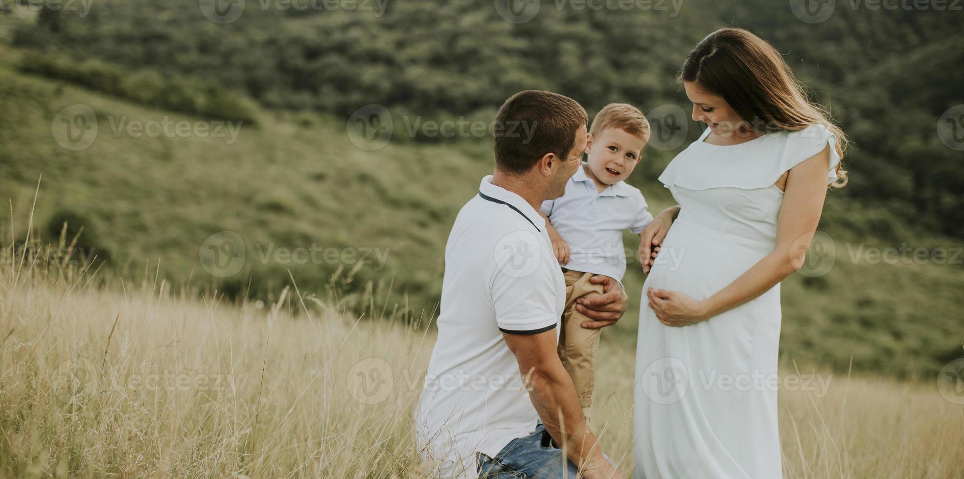 família jovem com garotinho fofo se divertindo ao ar livre no campo foto