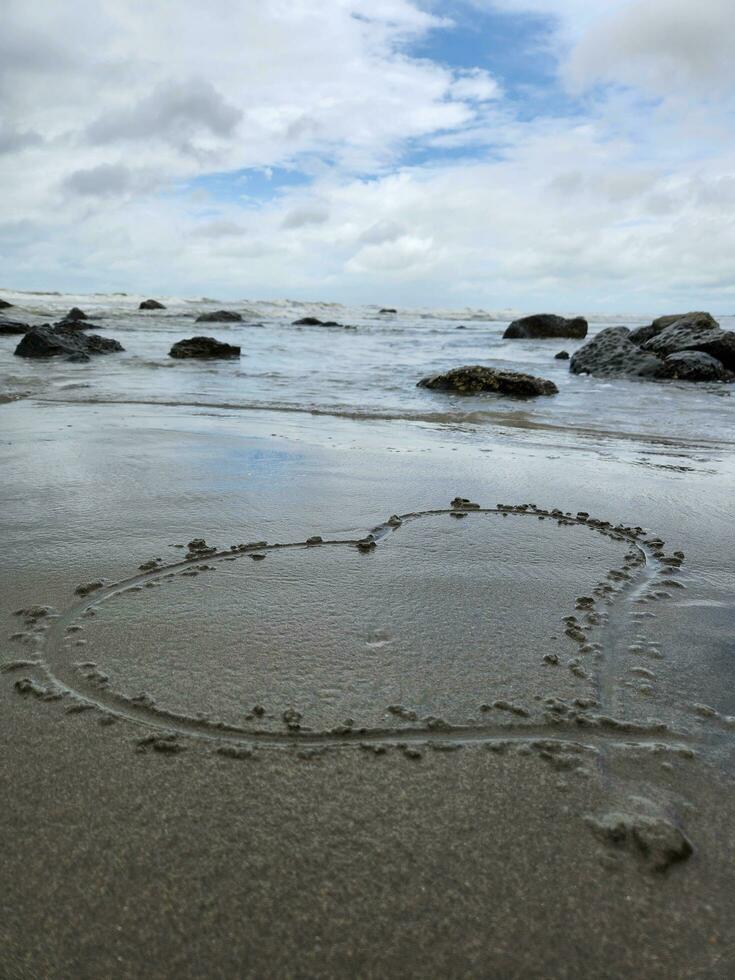 beira-mar em uma nublado dia branco arenoso de praia com amor ícone foto