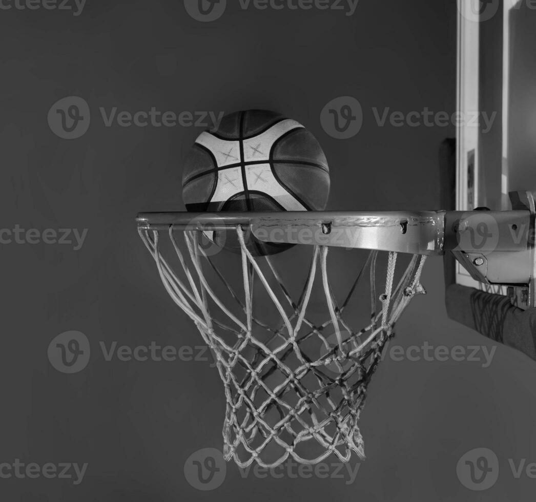 basquetebol bola queda para dentro a cesta em uma Preto fundo foto