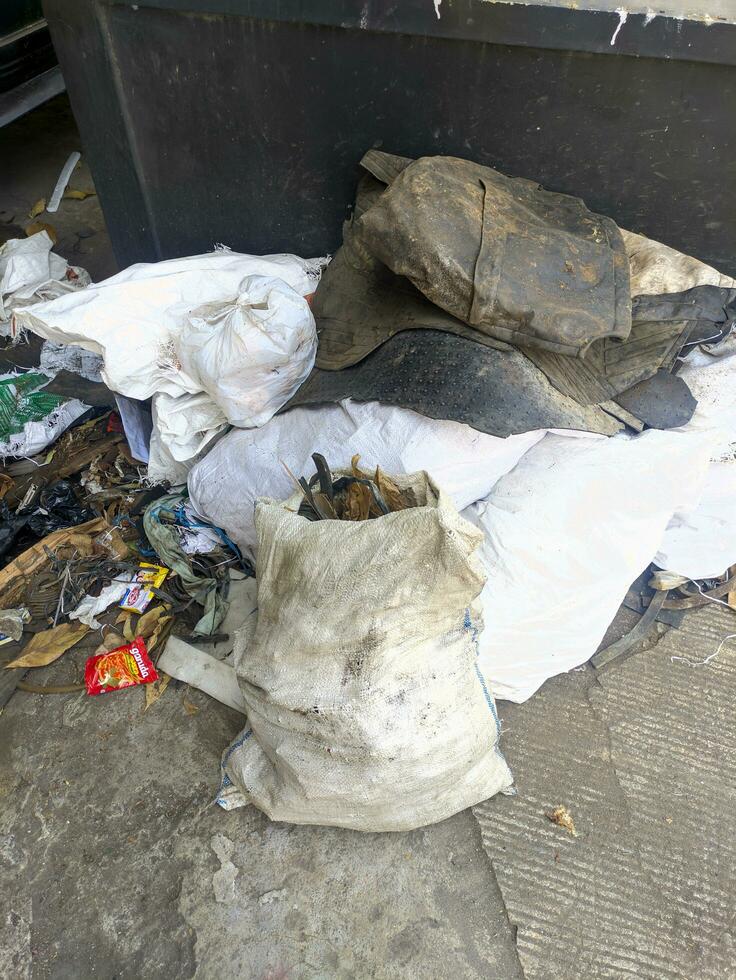 pilhas do lixo desperdício e lixo sacos em a lado do a estrada, lixo empilhado acima em a lado do a cidade estrada foto