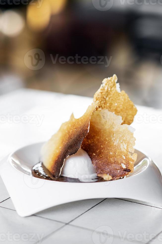 sorvete gourmet de baunilha madagascar com sobremesa de chips de leite doce torrado foto