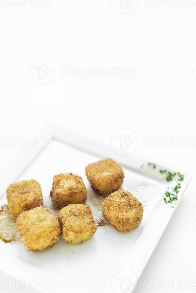 purê de batata frita, croquetes quadrados, acompanhamento vegetariano simples em prato branco foto