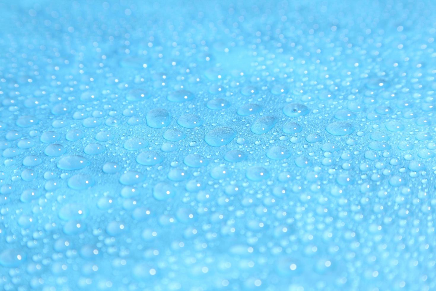 close-up gotas de água em fundo azul foto