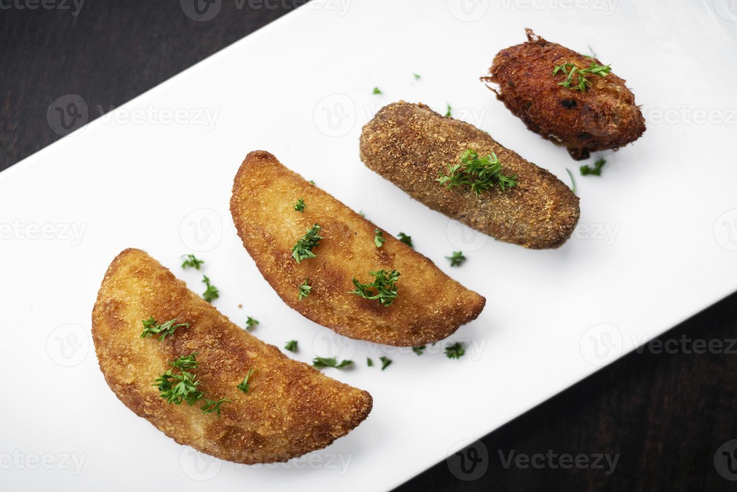 petiscos tradicionais portugueses mistas de tapas fritas no prato com rissole de camarão, croquete de bife e pepita de bacalhau foto