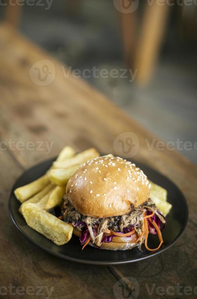 sanduíche de hambúrguer de salada de repolho com carne de porco desfiada e salgadinho de batata frita foto