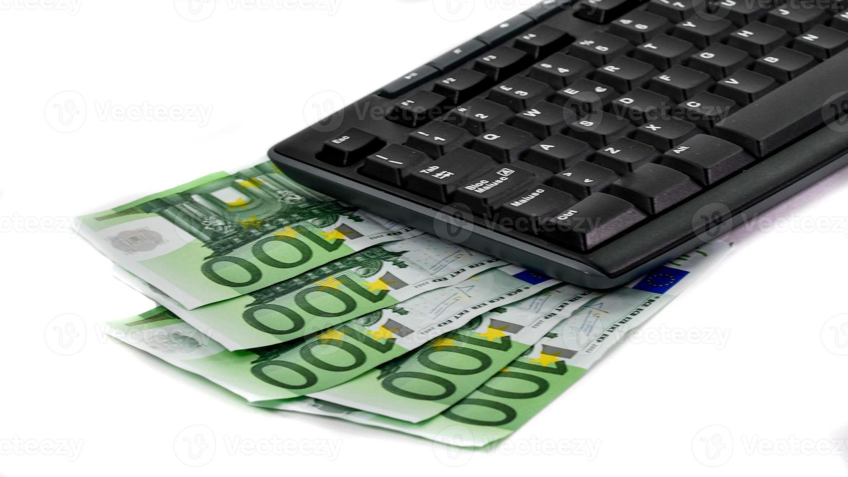 detalhe de um teclado de computador e notas de 100 euros foto