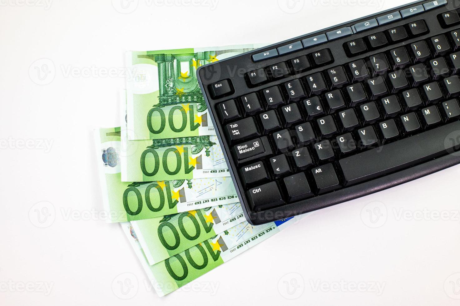 notas de 100 euros em forma de leque com teclado de pc foto