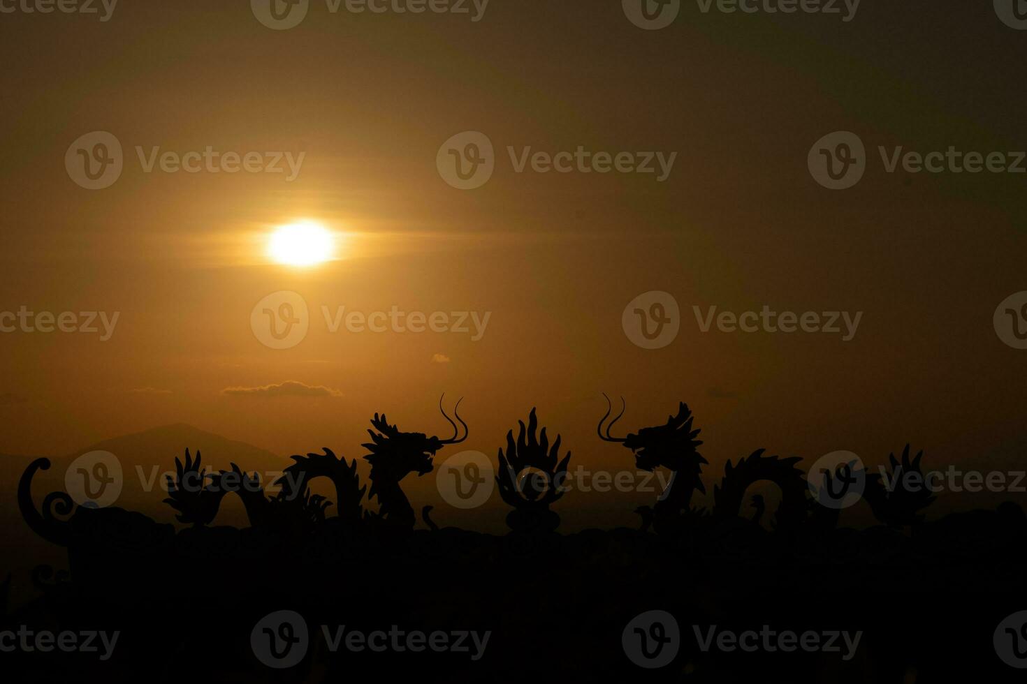 uma pôr do sol com Dragão estátuas dentro a fundo foto