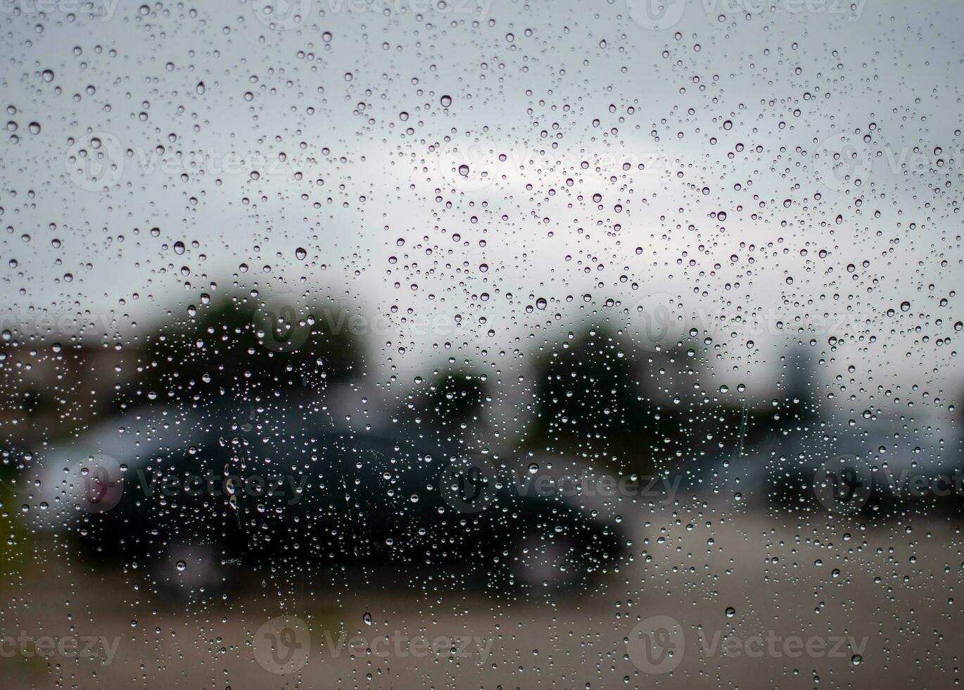 brilhante pingos de chuva em carro vidro, tarde depois de trabalhar, dentro a estacionamento, levar fechar-se a imagem, preto-cinza fundo, borrão, paisagem, e lindo imagem. foto