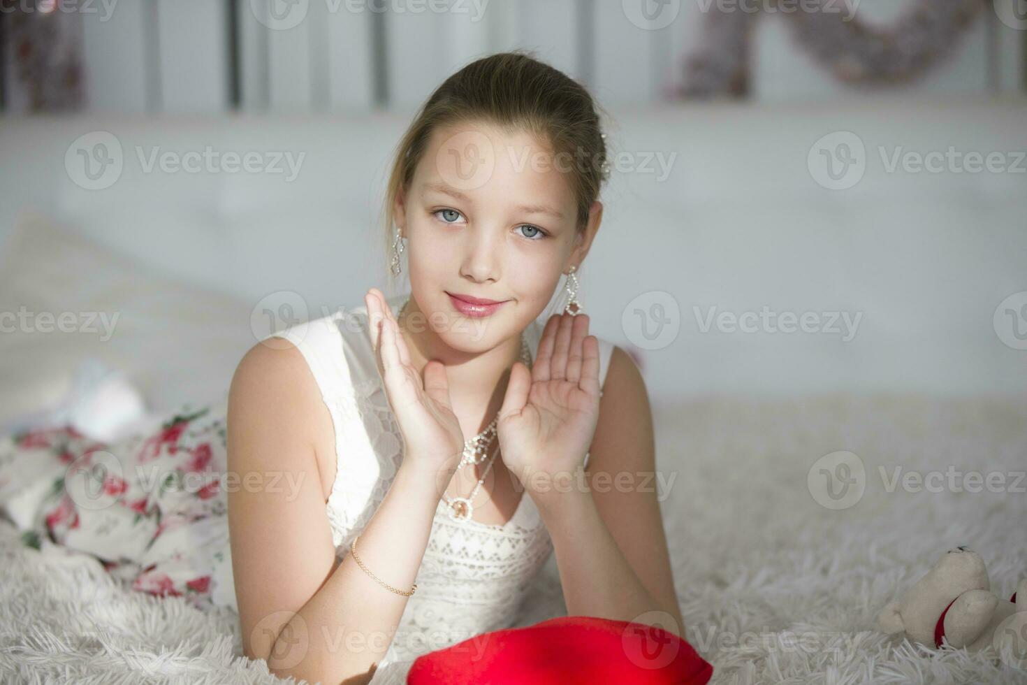 muito lindo adolescente menina deitado em uma cama com uma vermelho coração travesseiro.jovem senhora foto