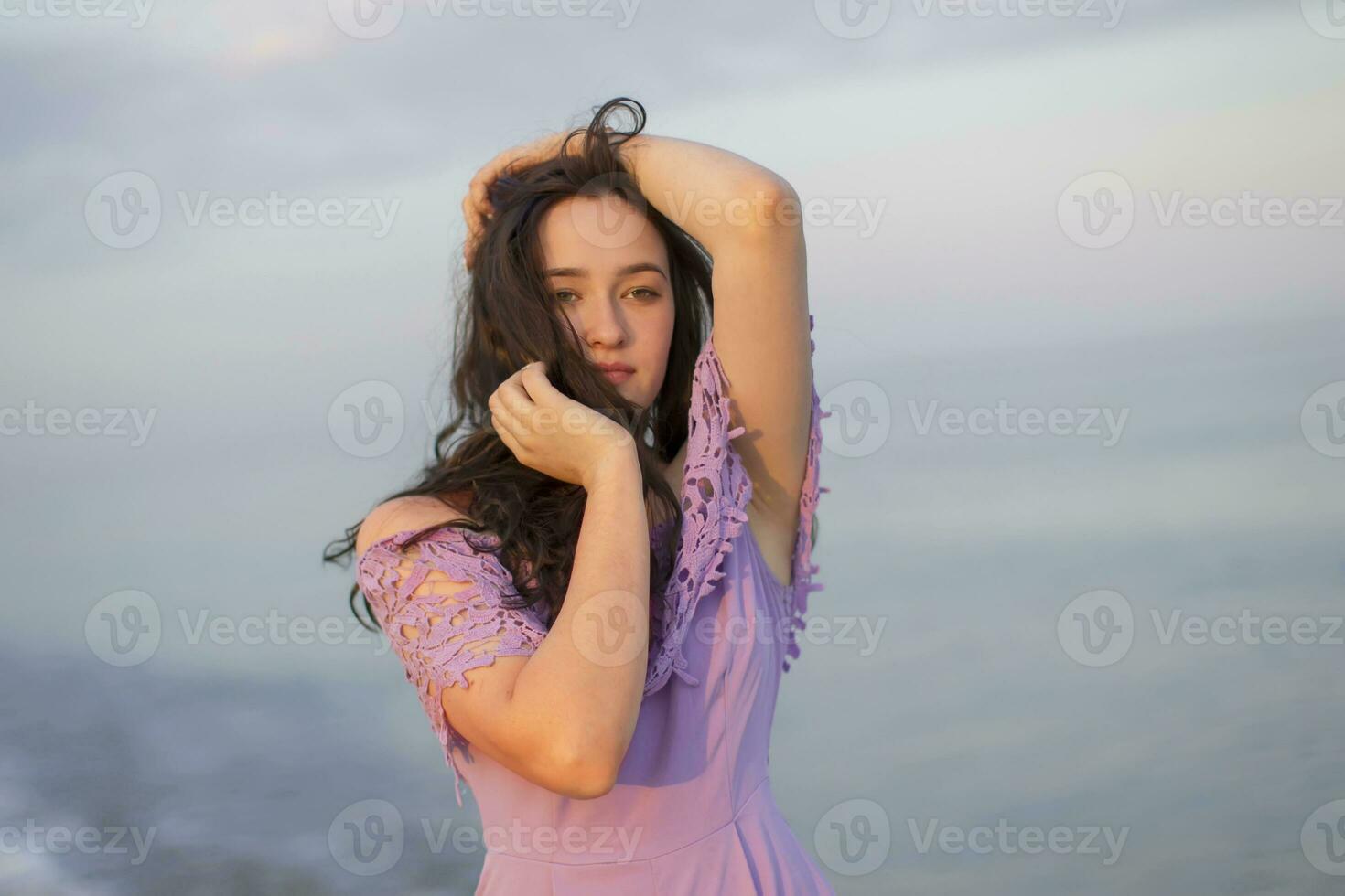 jovem comum menina do modelo aparência posando contra a fundo do a mar e céu foto
