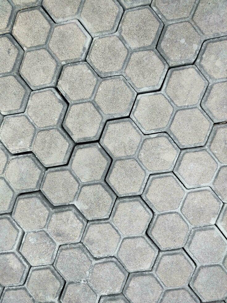 calçada hexagonal pedra fundo. hexagonal pavimentação godo textura liderar em cidade rua foto