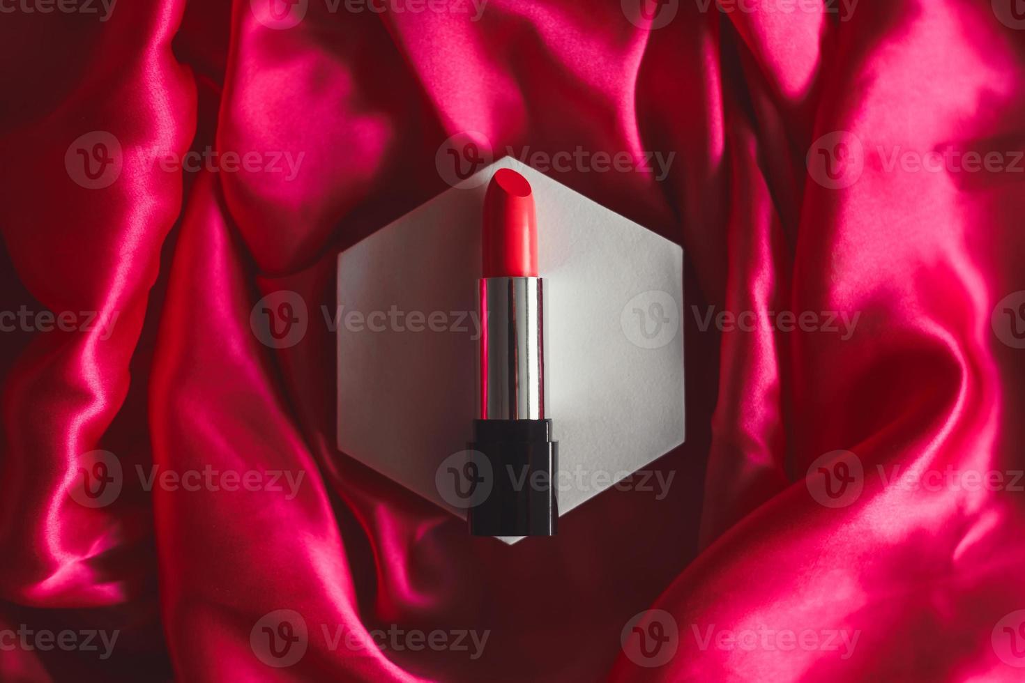 batom vermelho em um fundo de seda texturizado, cosméticos de beleza. foto