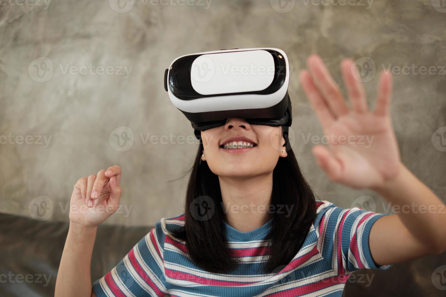 mulher asiática com fone de ouvido vr, assistindo a simulação virtual 3d. foto